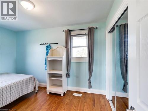 Hardwood-finish flooring throughout, featuring light blue walls and white trim - 9183 Silver Street, Caistor Centre, ON - Indoor Photo Showing Bedroom