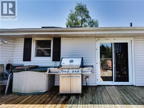 Outdoor deck with wood-finish flooring, white siding, and a sliding glass door - 9183 Silver Street, Caistor Centre, ON - Outdoor With Deck Patio Veranda With Exterior