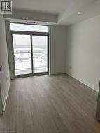 This room features light-toned flooring, white walls, and a sliding glass door providing a view - 