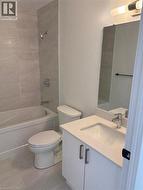 Bathroom featuring a white vanity with an integrated sink, a rectangular mirror, and a combination shower and bathtub - 