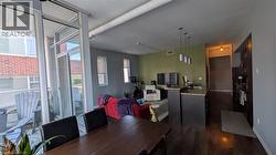 Open concept living space featuring hardwood floors, a kitchen island with pendant lighting, and access to an outdoor balcony - 