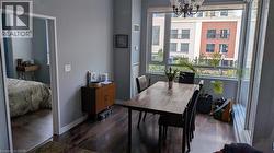 Dining area featuring hardwood floors, a large window providing ample natural light, and an overhead chandelier - 