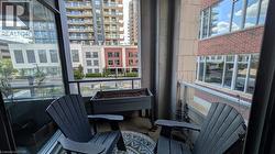 The property features a balcony with glass railings, offering views of buildings and the street below - 