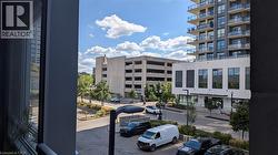 View of the urban environment, featuring a modern building with balconies and a parking area below - 