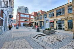 The property is situated within a vibrant commercial area featuring brick buildings and paved walkways - 