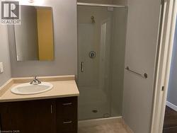 Bathroom featuring a vanity with a white oval sink, a glass-enclosed shower, and a mirror - 