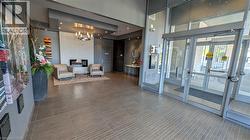 Welcoming lobby featuring a contemporary fireplace with a textured surround, recessed lighting, and a modern chandelier - 