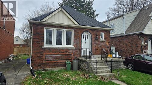 The property features a brick exterior, a driveway, and a front yard with a walkway leading to the front entrance - 66 Cline Avenue Unit# Main Floor, Hamilton, ON - Outdoor With Exterior