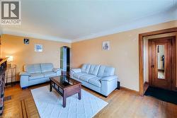 Hardwood flooring with inlaid details, complemented by a decorative wood-framed entryway with a full-length mirror - 