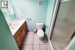 Full bathroom featuring a single vanity with wood-finish cabinetry, a white countertop, and an integrated sink - 