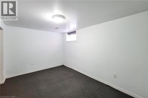 Room featuring gray carpeting, white painted walls, a flush-mount ceiling light fixture, a single window, and white trim - 66 Cline Avenue Unit# Main Floor, Hamilton, ON - Indoor Photo Showing Other Room