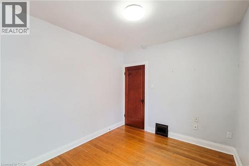 Room featuring wood-finish flooring, light-toned wall paint, and white trim - 66 Cline Avenue Unit# Main Floor, Hamilton, ON - Indoor Photo Showing Other Room