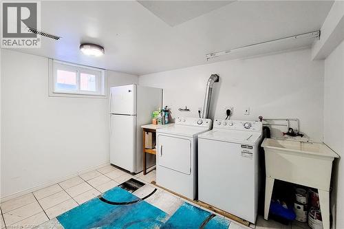 Laundry area featuring a utility sink, a window, and tiled flooring - 66 Cline Avenue Unit# Main Floor, Hamilton, ON - Indoor Photo Showing Laundry Room