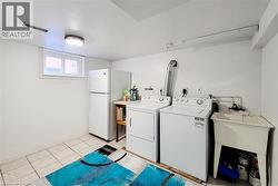 Laundry area featuring a utility sink, a window, and tiled flooring - 