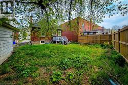 Expansive green space featuring perimeter fencing and a rear deck - 