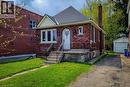 Brick exterior with white trim, arched entry door, a prominent front chimney, and a detached garage - 66 Cline Avenue Unit# Main Floor, Hamilton, ON  - Outdoor 