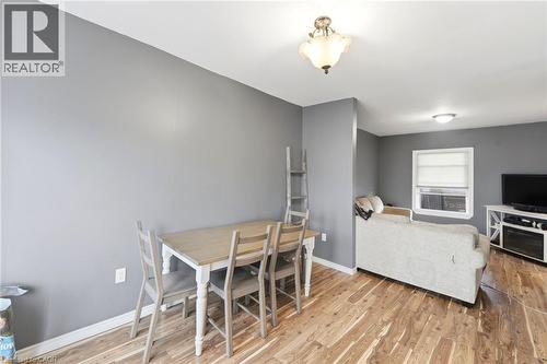 This interior space features hardwood flooring, neutral gray walls, and white ceiling trim - 99 Robins Avenue, Hamilton, ON - Indoor