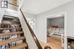 The property features a staircase with wood treads and a white baluster railing, complemented by a distinctive riser design - 