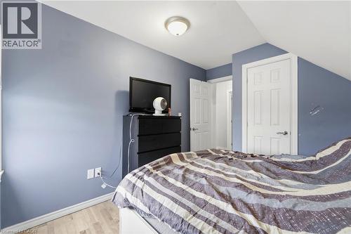 This room features light-toned flooring, a light blue wall color, and white trim - 99 Robins Avenue, Hamilton, ON - Indoor Photo Showing Bedroom