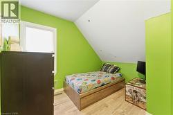 This room features a window providing natural light, bright green walls, and light-colored flooring - 
