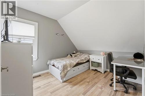 Room featuring light-colored wood flooring, a window with blinds, and walls painted in two different tones - 99 Robins Avenue, Hamilton, ON - Indoor