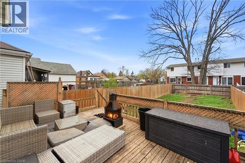 The property features a wooden deck with a privacy screen and a fenced yard - 99 Robins Avenue, Hamilton, ON - Outdoor With Deck Patio Veranda