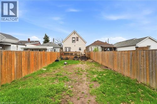 The property features a fenced yard with a deck and exterior stairs - 99 Robins Avenue, Hamilton, ON - Outdoor