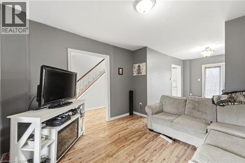 This living area features light wood flooring, neutral gray walls, and white trim - 99 Robins Avenue, Hamilton, ON - Indoor Photo Showing Living Room
