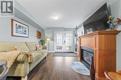 Living space featuring hardwood floors, a fireplace with a wood mantel, and french doors with decorative glass - 