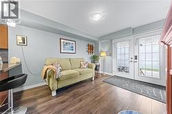 This inviting space features durable wood-look flooring, light-colored walls, and a set of double doors with frosted glass panels - 