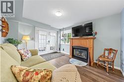 Living area featuring durable wood-look flooring, a fireplace with a wooden mantel, and French doors leading to the outdoors - 