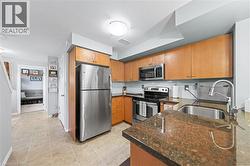 The kitchen features light wood cabinetry, stainless steel appliances, and granite countertops - 