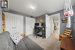 This room features two sets of white double doors, a ceiling light fixture, and carpeting - 