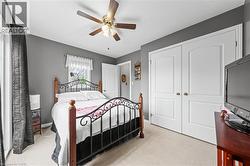 This room features a ceiling fan, a window, and double white closet doors - 