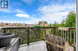 The property includes a deck with a wooden railing and a privacy screen - 