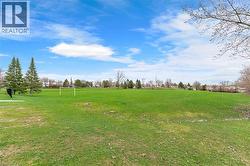 Expansive green space featuring well-maintained grass and mature trees - 