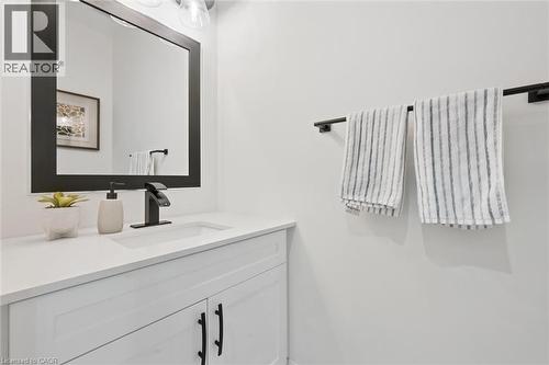 White vanity with shaker-style cabinetry, black hardware, and an integrated rectangular sink - 213 Fallowfield Drive, Kitchener, ON - Indoor Photo Showing Bathroom