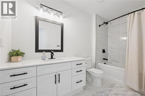 White vanity with black hardware, a rectangular undermount sink, and a black single-handle faucet - 213 Fallowfield Drive, Kitchener, ON - Indoor Photo Showing Bathroom