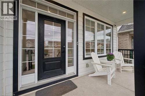 Inviting covered front porch with white siding and contrasting black trim - 213 Fallowfield Drive, Kitchener, ON - Outdoor With Deck Patio Veranda