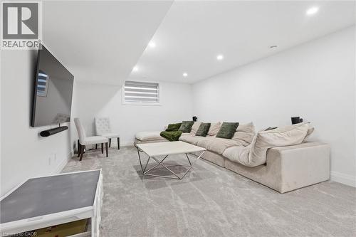 Spacious recreational area featuring recessed lighting, a large window with horizontal blinds, and light-toned wall-to-wall carpeting - 213 Fallowfield Drive, Kitchener, ON - Indoor