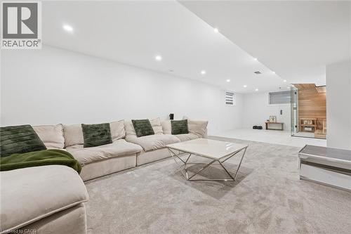 Spacious room featuring light-colored carpeting, recessed lighting, white walls, and a glass-enclosed sauna with wood-paneled interior - 213 Fallowfield Drive, Kitchener, ON - Indoor Photo Showing Living Room