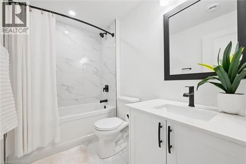 Bathroom featuring a white vanity with integrated sink, quartz-finish countertop, and matte black fixtures - 213 Fallowfield Drive, Kitchener, ON - Indoor Photo Showing Bathroom