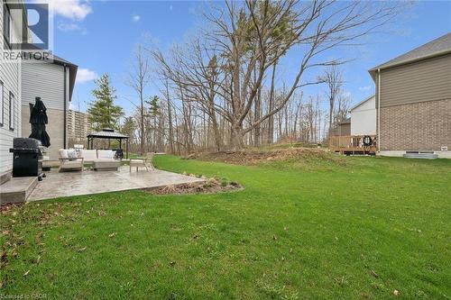 Expansive green lawn with a concrete patio directly accessible from the house - 213 Fallowfield Drive, Kitchener, ON - Outdoor