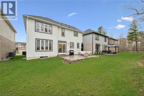 Expansive backyard featuring a large green lawn, paver patio, and sliding glass door access to the interior - 213 Fallowfield Drive, Kitchener, ON - Outdoor With Exterior