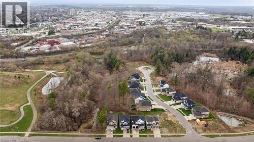 Modern residential development featuring single-family homes with attached garages, surrounded by natural woodlands and a paved walking path - 213 Fallowfield Drive, Kitchener, ON - Outdoor With View