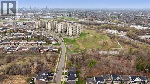 Aerial perspective showcasing residential developments, multi-story buildings, and a natural green expanse with a pond - 213 Fallowfield Drive, Kitchener, ON - Outdoor With View
