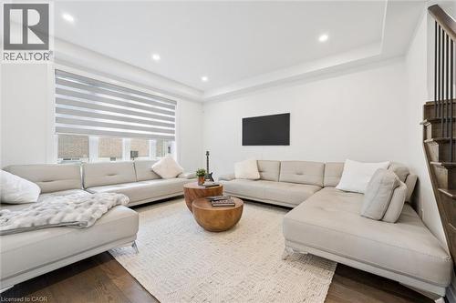 Bright living space featuring dark wood-finish flooring, recessed lighting, and a tray ceiling - 213 Fallowfield Drive, Kitchener, ON - Indoor Photo Showing Living Room