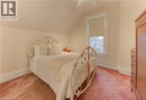 This room features sloped ceilings, a window providing natural light, and plush carpeting - 48 Dupont Street, Waterloo, ON - Indoor Photo Showing Bedroom
