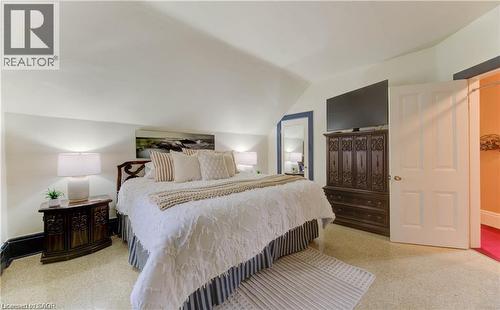 This room features a vaulted ceiling, light-colored carpeting, and a white paneled door - 48 Dupont Street, Waterloo, ON - Indoor Photo Showing Bedroom