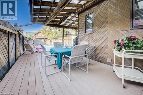 The property features a spacious outdoor deck area with a covered patio, providing a private space for relaxation - 48 Dupont Street, Waterloo, ON - Outdoor With Deck Patio Veranda With Exterior